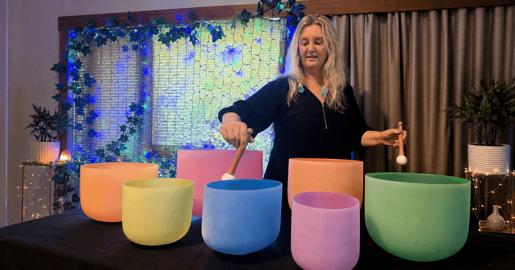 Nic playing colourful sound bowls at her Riverside massage practice