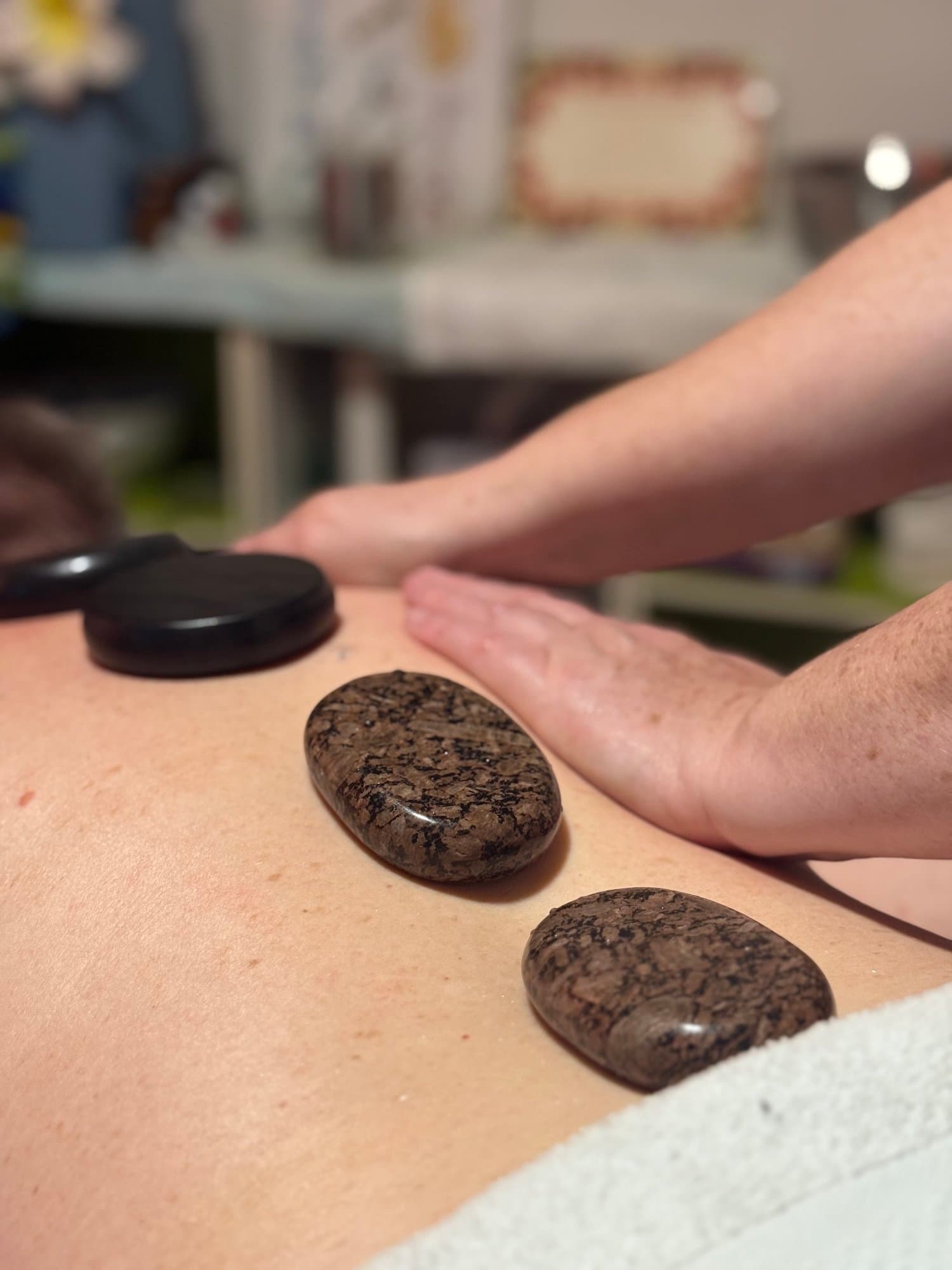 Nicole combining hot stones and hands-on massage during a Body and Soul session