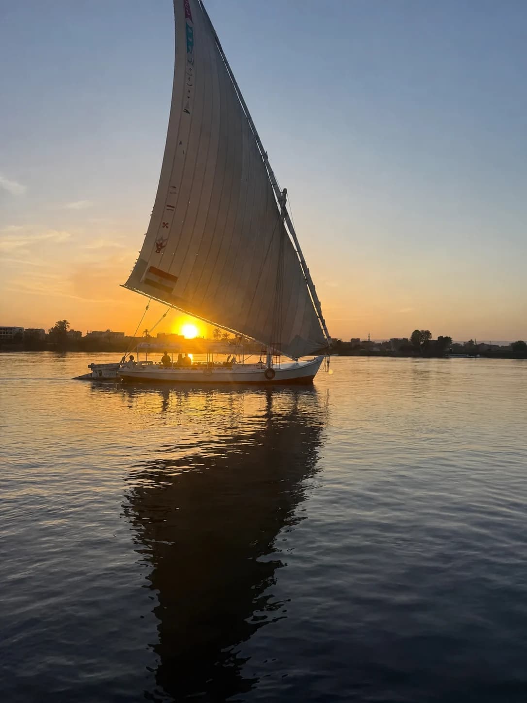 A traditional felucca sailing on the Nile at sunset