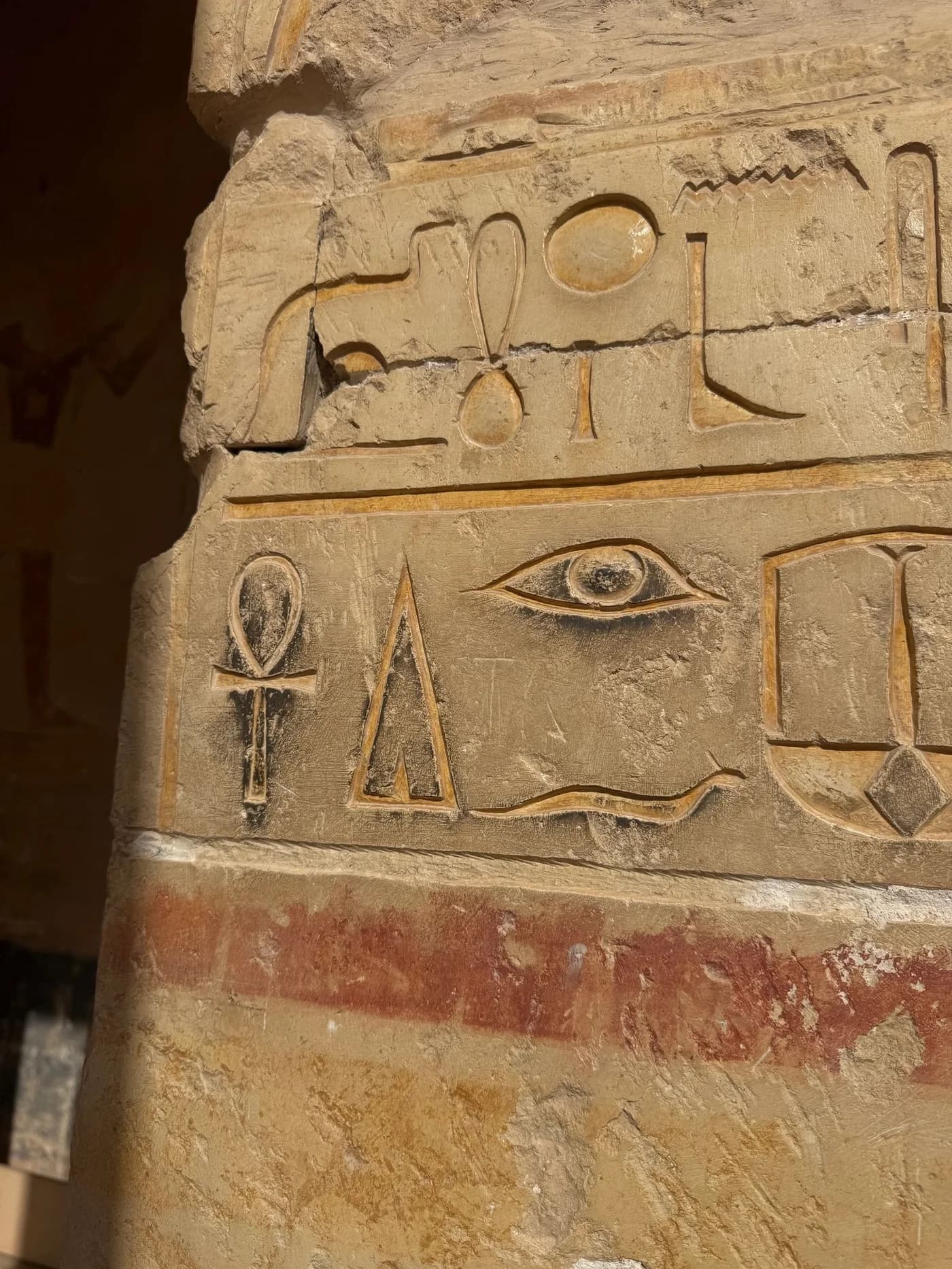 Ancient Egyptian temple carvings featuring the Eye of Horus and an ankh